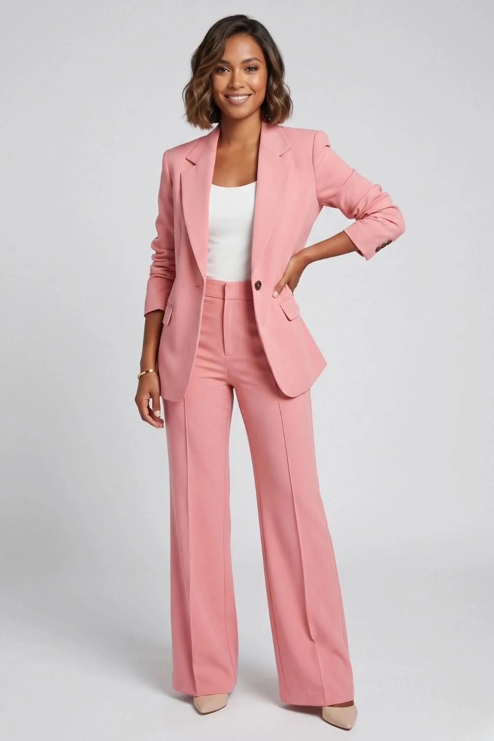 Woman wearing a pink suit with a white top on a gray background