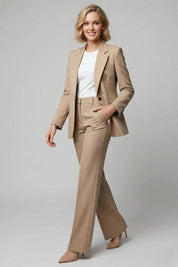Woman wearing a beige suit with a white shirt on a gray background