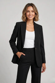 Woman wearing a black suit with a white top on a gray background