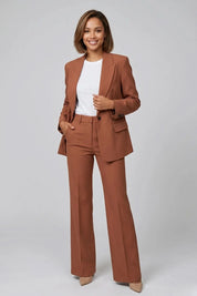 Woman wearing a brown suit with a white shirt on a gray background