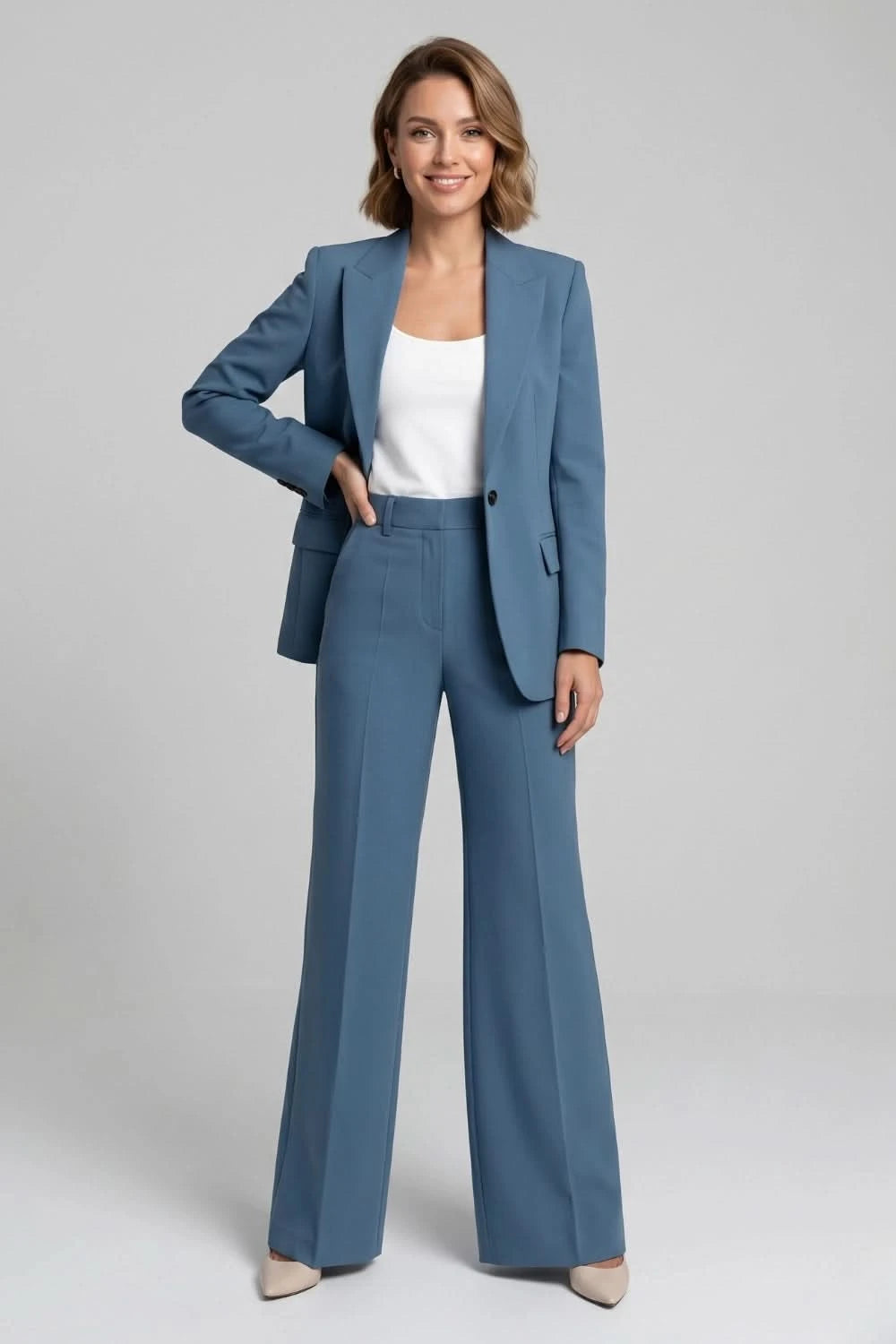 Woman wearing a blue suit with a white top on a gray background