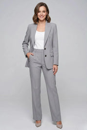 Woman wearing a gray suit with a white top on a gray background