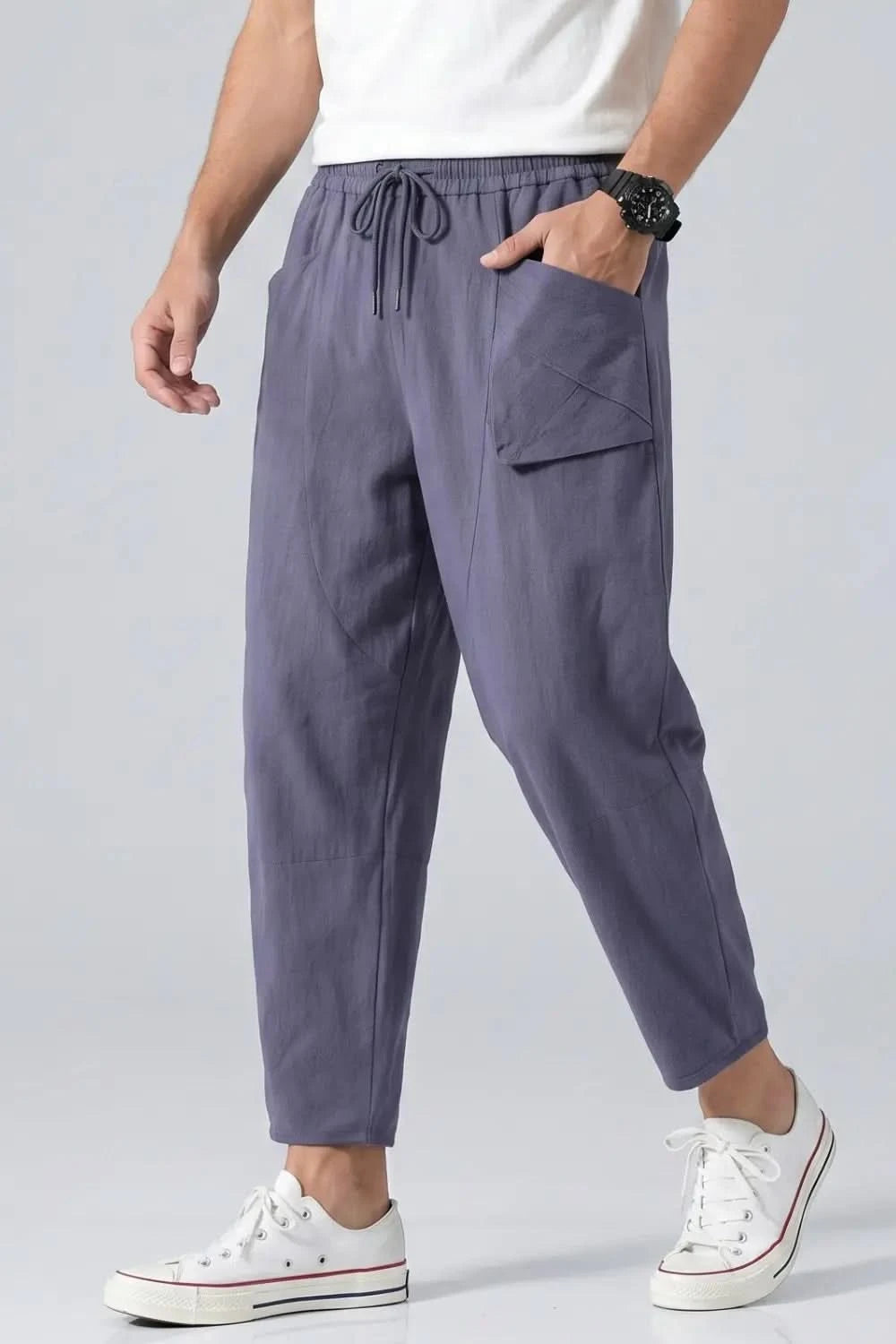 Person wearing gray jogger pants with a white background