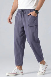 Person wearing gray jogger pants with a white background
