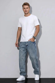 Man wearing a white t-shirt and blue jeans against a plain background
