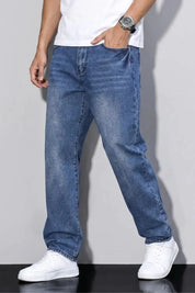 Person wearing blue jeans and white sneakers against a plain background
