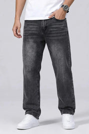 Person wearing black jeans and white sneakers on a plain background