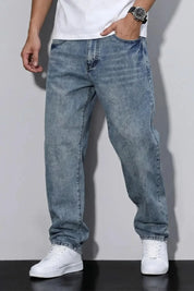 Person wearing blue jeans and white sneakers on a plain background