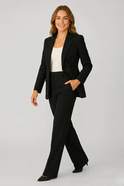 Woman wearing a black suit with a white top on a gray background