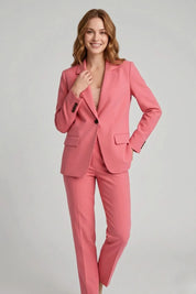 Woman wearing a pink suit on a gray background