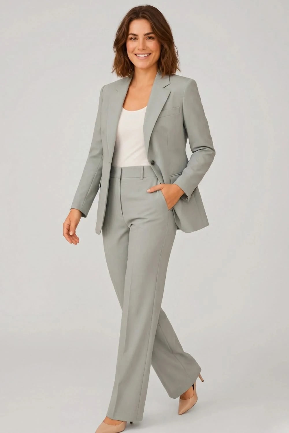 Woman wearing a gray suit with a white top on a light gray background
