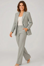 Woman wearing a gray suit with a white top on a light gray background