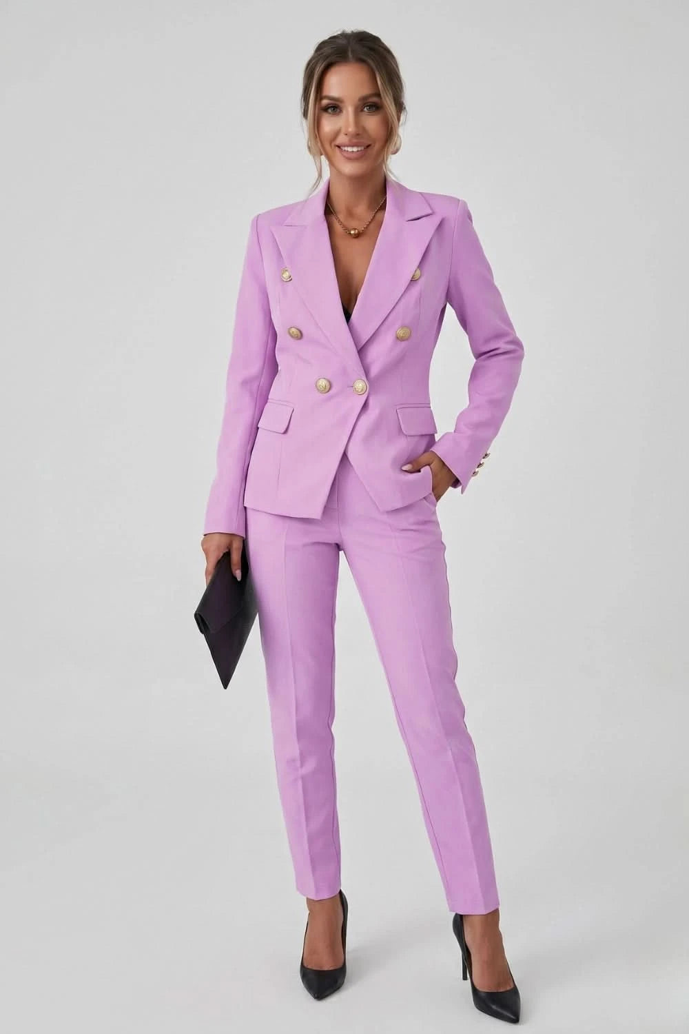 Woman wearing a pink suit with gold buttons on a white background