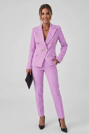 Woman wearing a pink suit with gold buttons on a white background