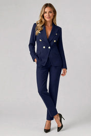 Woman wearing a navy blue suit with gold buttons on a gray background