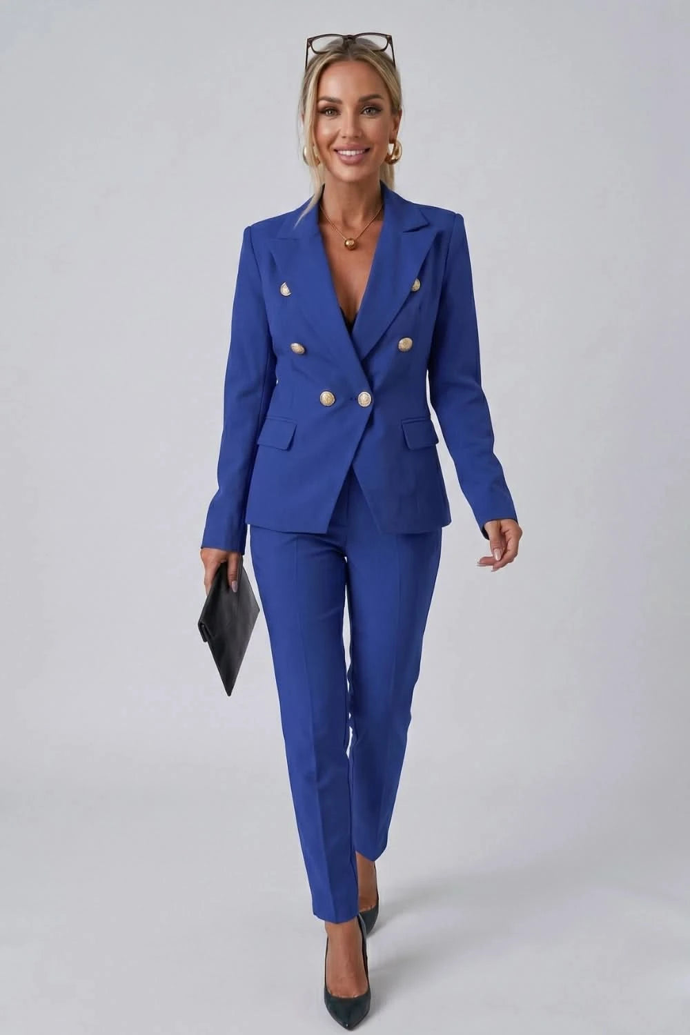 Woman wearing a blue suit with gold buttons on a gray background