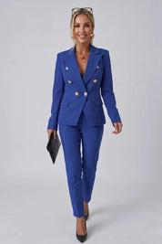 Woman wearing a blue suit with gold buttons on a gray background