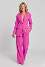 Woman wearing a bright pink suit on a light gray background