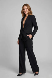 Woman wearing a black suit on a gray background