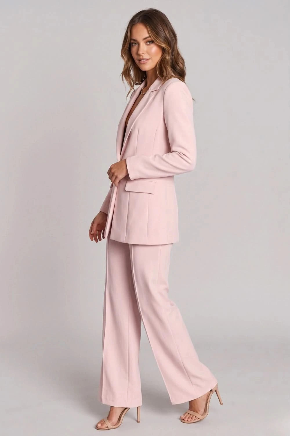 Woman wearing a pink suit on a gray background