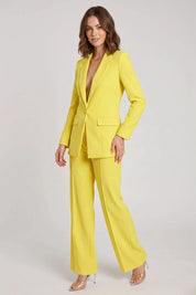 Woman wearing a bright yellow suit on a white background