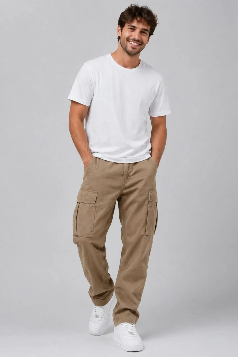 Man wearing a white t-shirt and beige cargo pants on a gray background