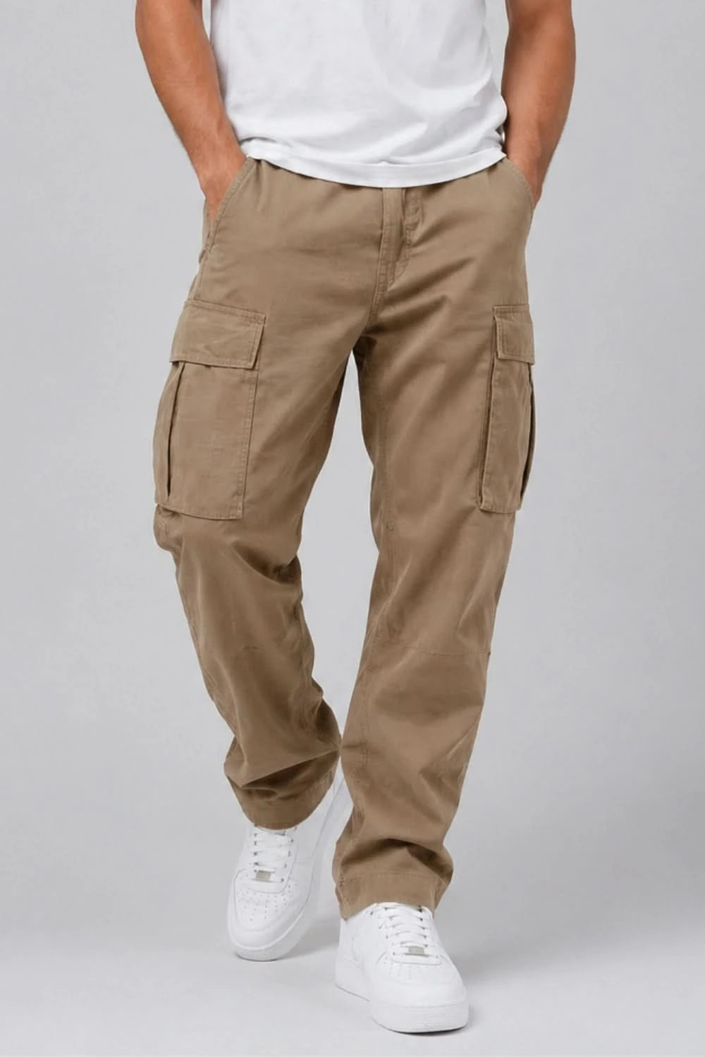 Person wearing beige cargo pants and white sneakers on a plain background