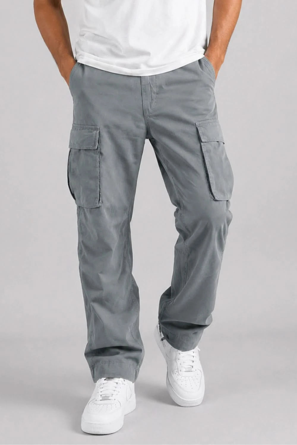 Person wearing gray cargo pants on a plain background