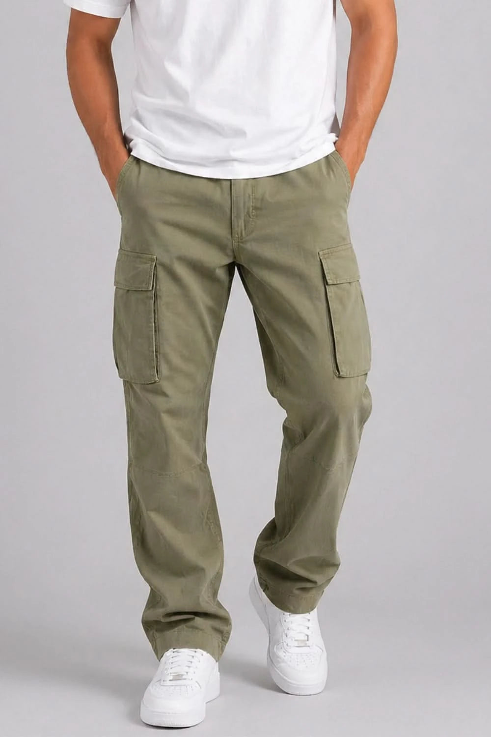 Person wearing olive green cargo pants and white sneakers on a gray background