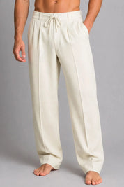 Beige lounge pants worn by a person on a gray background