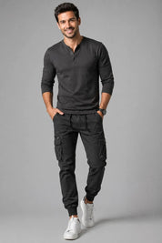 Man wearing a black long-sleeve shirt and cargo pants on a gray background