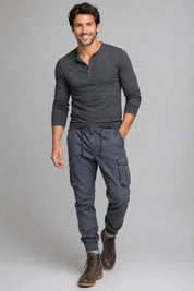 Man wearing a gray long-sleeve shirt and cargo pants on a gray background
