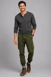 Man wearing a dark gray long-sleeve shirt and green cargo pants on a gray background